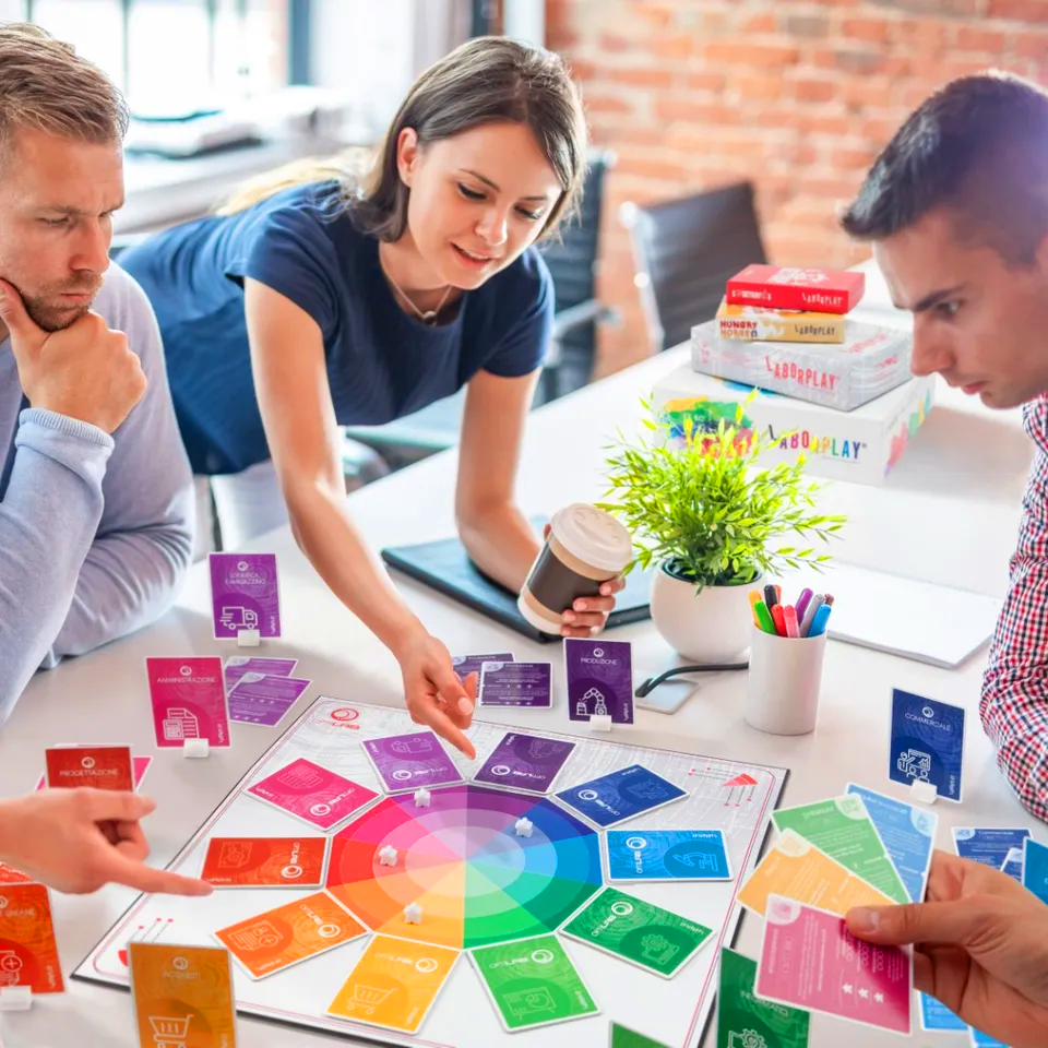 persone intorno ad un tavolo che giocano ad un gioco in tavola colorato per fare formazione aziendale